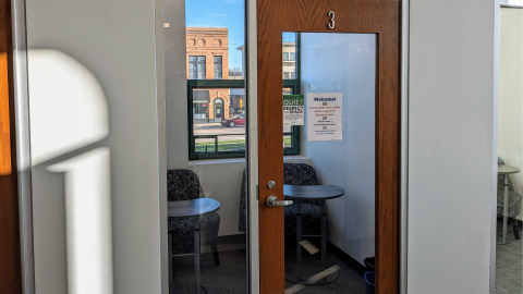 Looking into the door and windows, there two chairs and two small tables in the quiet study room 3. There is also a window to the park.