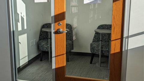 Looking into the door and windows, there are two chairs and two small tables in the quiet study room 4.