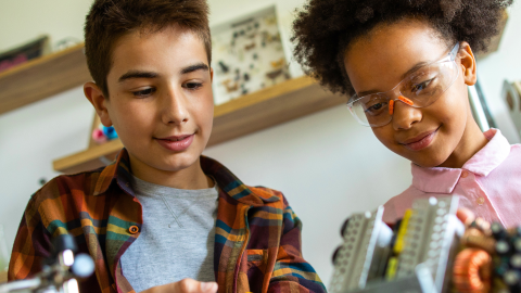 Two young kids work on a STEM project together