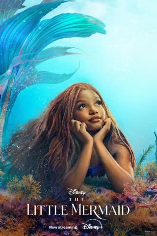 A young mermaid sits on the ocean floor with head resting on her hands looking longingly up to the surface