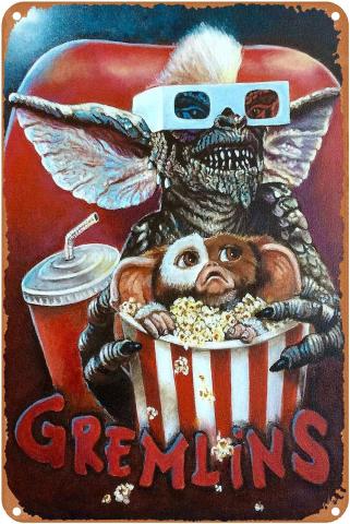 A scaly creature with big bat-like ears, a fluffy stripe on its head sits in a theater chair grinning with sharp teeth, holding a striped tub of popcorn with a smaller, cuter, fluffier creature inside looking scared.